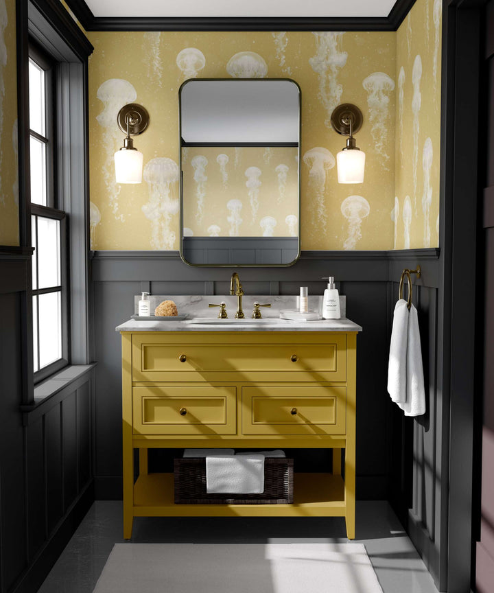 Luxury jellyfish wallpaper with delicate jellyfish patterns in a mustard yellow bathroom setting with black wainscoting and gold fixtures