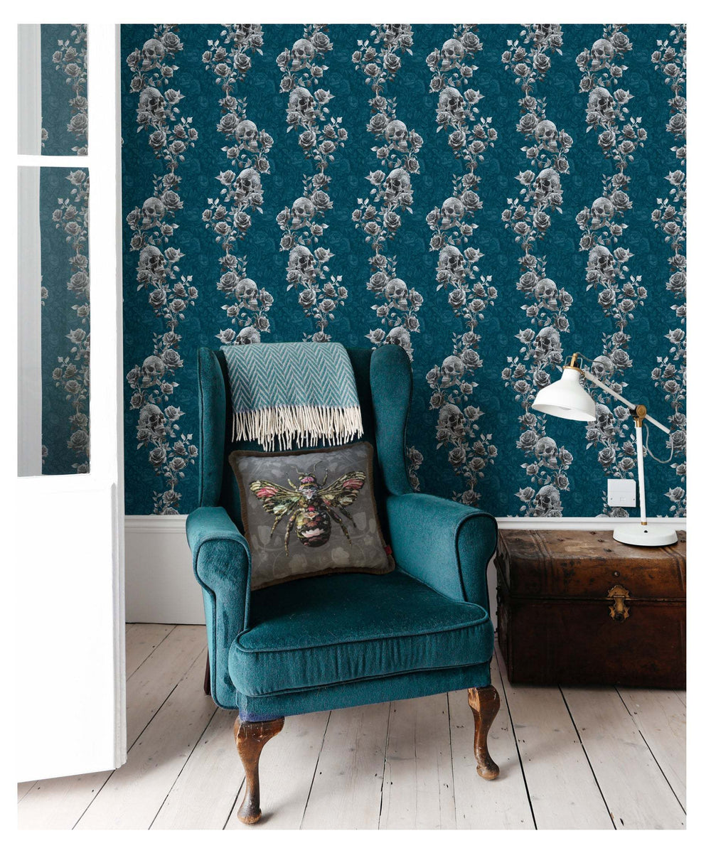 Blue Skull and Roses wallpaper in a living room with teal armchair and vintage decor