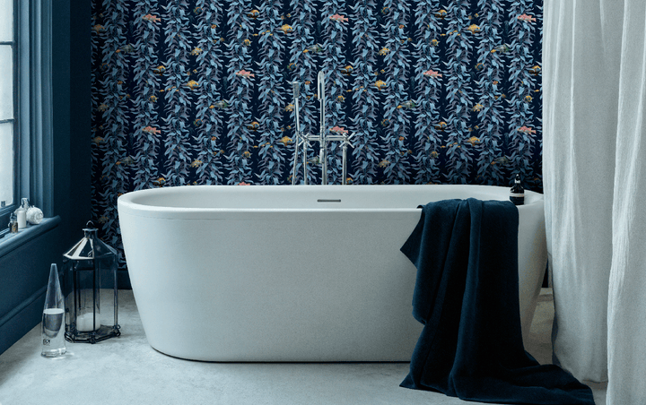 Bathroom with luxury ocean wallpaper featuring sea kelp fish design in sea blue behind a modern white freestanding bathtub